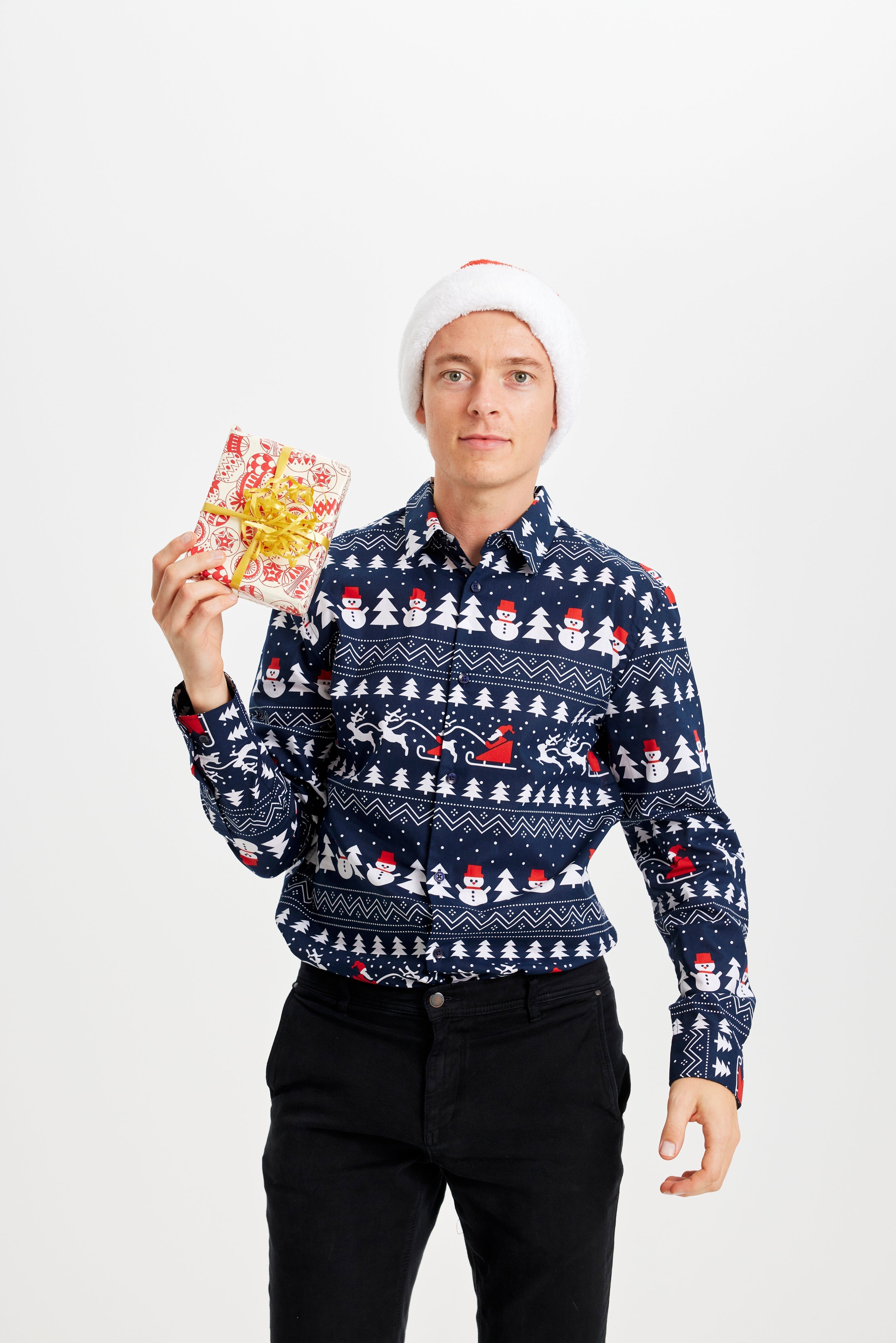 Een man met een cadeautje in een blauw kerstshirt.